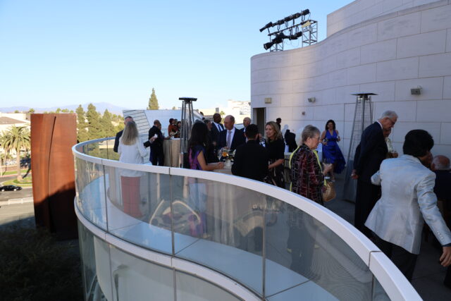 An outdoor terrace at Segerstrom Center for the Arts, with guests in cocktail attire mingling