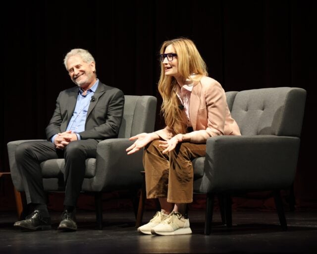 Two people in chairs on stage