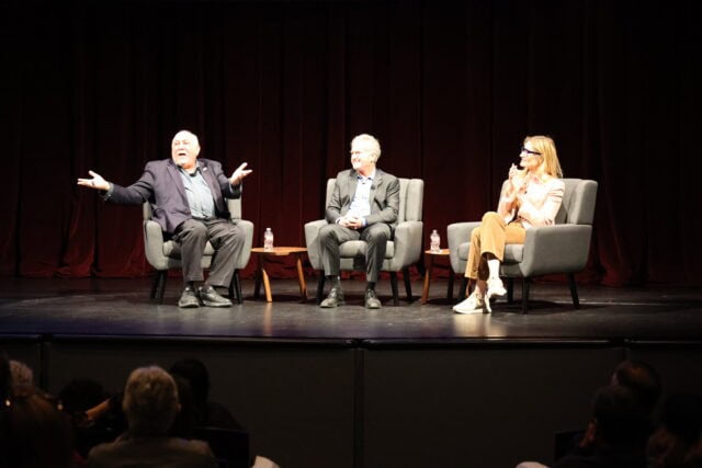 Three people in chairs on stage