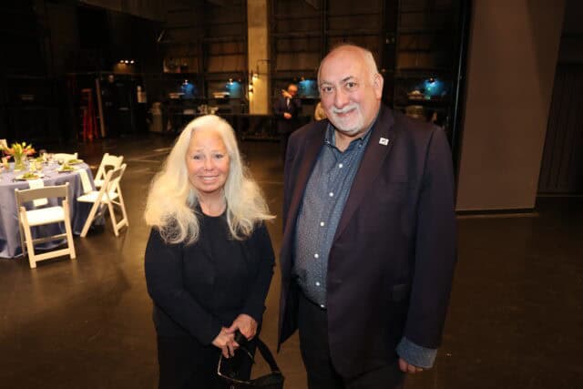 A woman and a man smile for the camera from the Barclay Theatre stage