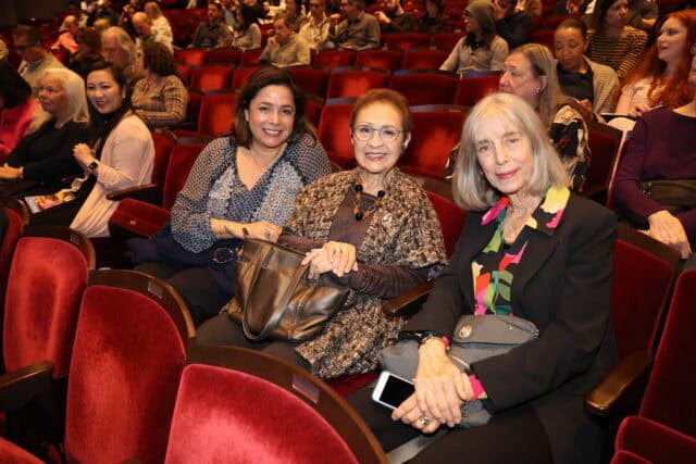 Three people in the upholstered red seats of the Barclay Theatre
